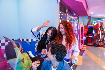 Group of young friends enjoying their time playing arcade games in a bowling alley and...