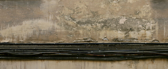 Electrical cables on the background of an old wall