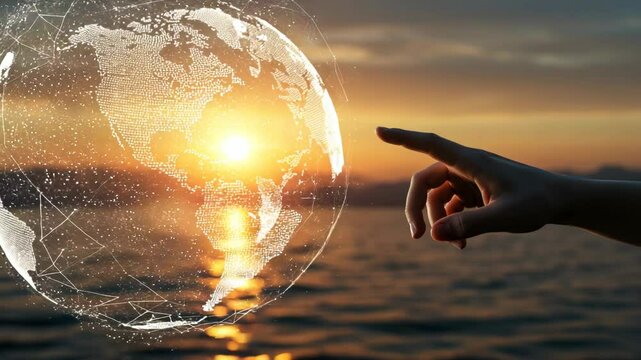 Hand touches digital earth globe over ocean at sunset, depicting global connection and future technology