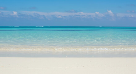 Obraz premium Pristine white sand beach with crystal clear turquoise waters under blue sky with fluffy clouds. Tropical paradise destination. Exotic vacation getaway. Summer holiday landscape. Ocean serenity