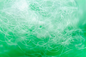 Extreme macro of polyester stable fiber on green background. Selective focus, shallow depth of...