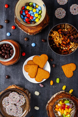 Various sweet food on black chalkboard background. Flat lay. Top view. Food concept.