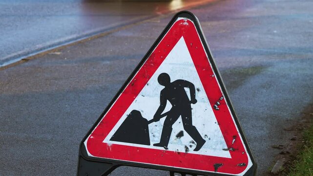 Construction warning sign in United Kingdom. Traffic notice board indicating roadwork ahead in Britain. Road safety marker showing highway maintenance in England