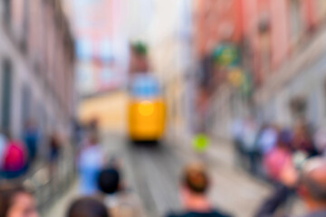 Blurred yellow tram and tourists, Lisbon, the capital city of Portugal.