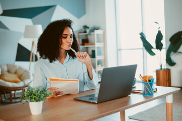 Young female deeply concentrated on tasks, working from a home office during daylight, showcasing a...