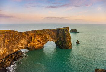 Natural lava arch in the sea. Cape Dyrholaey, coast of Iceland. Popular tourist attraction. Beauty world.