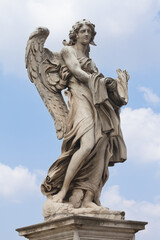Fototapeta premium Marble statue of an Angel by famous sculptor Gian Lorenzo Bernini on the Ponte Sant'Angelo, Bridge of Angels at the Castel Sant'Angelo in Rome, Italy