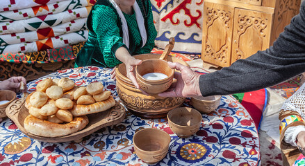 pouring traditional Asian drink kumis into a wooden vessel