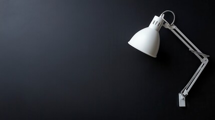 White desk lamp on dark background, copy space.
