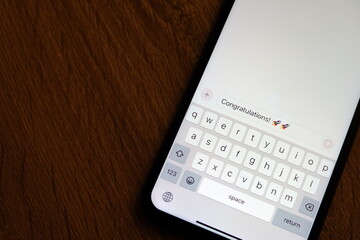 Text Message Display on Smartphone with "Congratulations!" and Emoji
