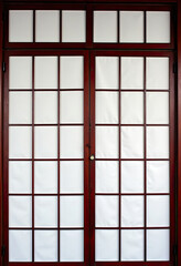 エレガントな和風紙屏風：茶色のフレームに白い正方形の紙、赤い布製のドアカーテンが特徴的なデザイン、24個の長方形の窓、ミニマリストな美学。
