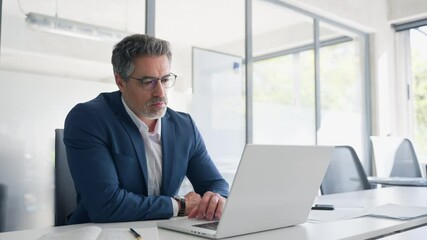 Focused senior businessman entrepreneur sitting at desk working on financial project, looking thinking at screen. Mature 50s Latin business man ceo manager using laptop computer in office. Copy space - Powered by Adobe