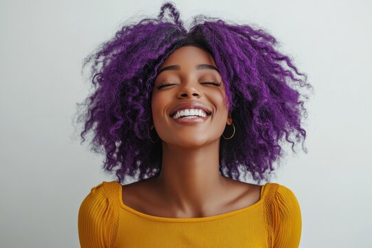Celebrating joy and vibrancy with a joyful Black woman dancing in a lively yellow top and stunning purple hair against a white backdrop - Powered by Adobe