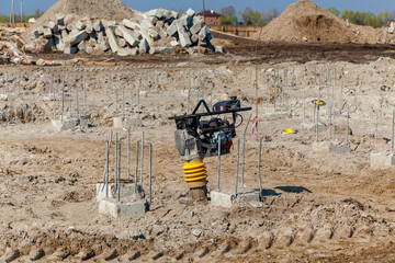 Construction site with foundation rebar and compactor machine