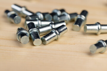 rivets to install shelves in cabinets, furniture metal fittings on a wooden board