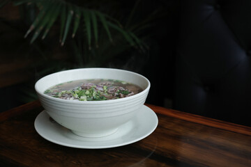 Traditional Vietnamese pho soup with beef slices served in a white ceramic bowl, copy space for text. Concept of authentic Asian cuisine, healthy food and comforting homemade meals.