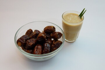 Glass of Sweet Date Smoothie and Bowl of Fresh Dates on White Surface