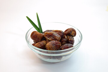Bowl of Fresh Dates with Green Leaf on White Background