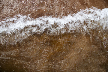 Brown sea waves rolling gently, creating a natural texture of water movement and earthy tones. serene coastal scene with soft wave patterns. Sea storm background