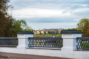 Antique bridge with fence on the background of old town landscape.