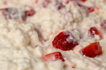 cottage cheese with sour cream and fresh strawberries, white sour-milk cottage cheese with strawberries cut into pieces