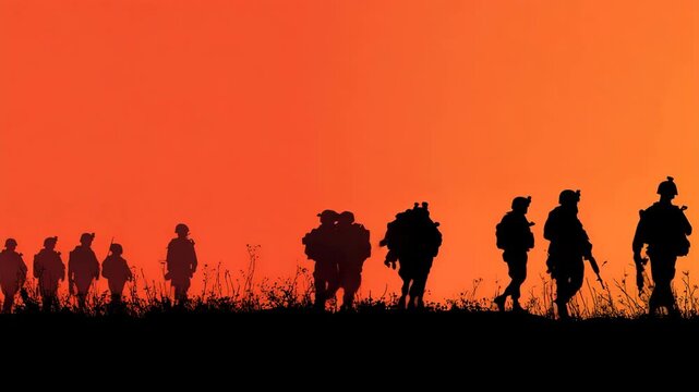 Silhouette of soldiers walking against a vibrant sunset sky