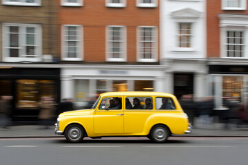 Taxi driver navigates busy street in a classic yellow cab during a bustling urban evening