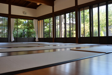 Traditional dojo features tatami mats and training weapons in a serene, sunlit environment