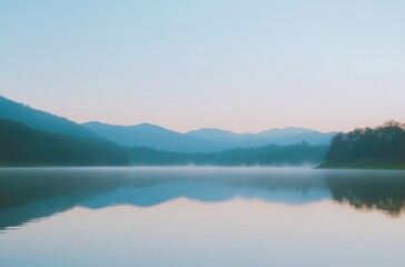 Fototapeta premium Mountains at dawn with cool-toned mist and tranquil lake reflections