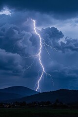lightning strikes through the sky over a mountain range in a storm