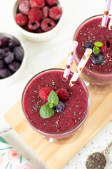 Raspberry blueberry smoothie with chia seeds and fresh mint. Top view. Healthy vegan blended drink for breakfast.
