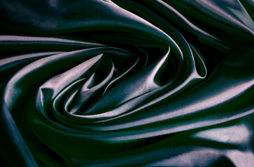 Top view of polished dark grey silk cloth with silky sheen and beautiful natural draping. Suitable for design and wallpaper background