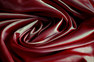 Top view of polished dark red silk cloth with silky sheen and beautiful natural draping. Suitable for design and wallpaper background