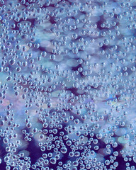 Abstract background with air bubbles in water in blue and purple tones.