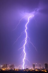 A powerful lightning bolt streaks across a twilight sky above a cityscape, illuminating the buildings below with its intense, bright light