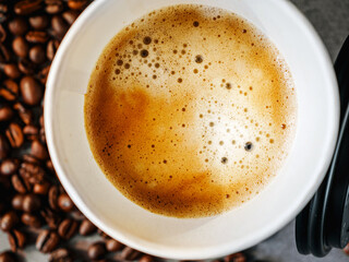Coffee crema espresso in paper Coffee cup and bean, close-up, Top view of Espresso in  Takeaway paper coffee cup