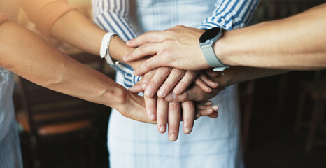 Hands, stack and teamwork for group at cafe with support, motivation or start morning with catering...