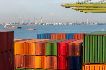 View on the containers loaded on deck of the cargo ship. She is berthed under gantry cranes in the...
