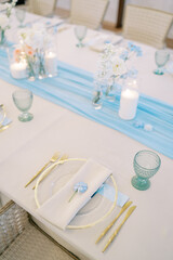 Blue flower lies on a napkin on a plate on a festive table