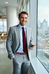 Confident businessman in a stylish suit enjoys a moment during a bustling workday, overlooking a vibrant city skyline
