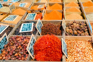 Colorful dried spices and herbs in wooden boxes at traditional food market