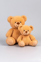 Obraz premium Two plush teddy bears, one large and one small, sit together against a neutral backdrop They are light brown with simple embroidered features