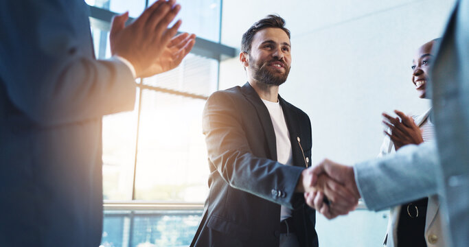 Office, handshake and man with business people with applause for success, congratulations and celebration. Corporate, deal and men and women shaking hands for job promotion, achievement or onboarding