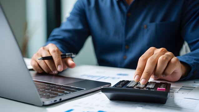 Close up businessman hand using calculator to budgeting and tax calculation monthly expenses. budget management and accounting on table. Business finance accounting banking concept.