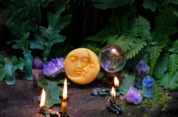 burning candles, amulet of moon, minerals, crystal quartz ball in forest, natural background....