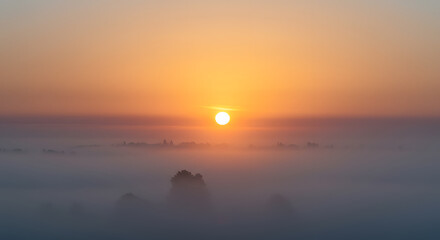 Sunrise Over Misty Landscape Scenery with Morning Glow