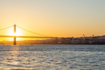 Fototapeta premium 25th of April Suspension Bridge and Tagus River at Sunset. Lisbon, Portugal. Golden Hour
