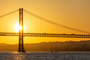 Obraz premium 25th of April Suspension Bridge and Tagus River at Sunset. Lisbon, Portugal. Golden Hour