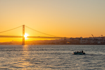 25th of April Suspension Bridge, Boat and Tagus River at Sunset. Lisbon, Portugal. View from Cacilhas. Golden Hour