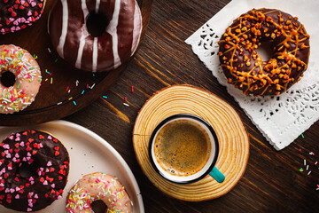 Cup with coffee and donuts on a wooden background. Top view